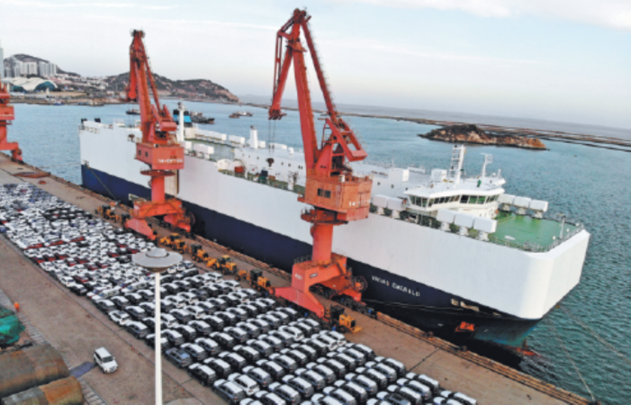 A cargo ship loads up vehicles for export at the Lianyungang Port in East China's Jiangsu province on Dec 14. [Photo by WANG CHUN/FOR CHINA DAILY]