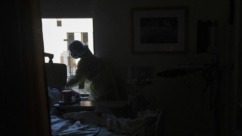 A nurse wearing personal protective equipment administers medication to a patient inside the covid-19 ward at PeaceHealth Southwest Medical Center in Vancouver, Wash., on April 30, 2020. MUST CREDIT: Bloomberg photo by Nathan Howard