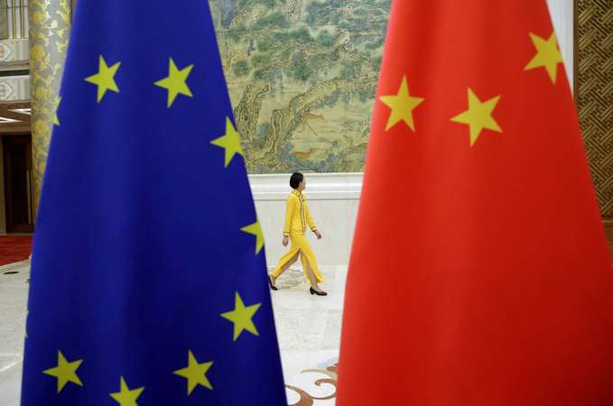 An attendant walks past EU and China flags ahead of the EU-China High-level Economic Dialogue at Diaoyutai State Guesthouse in Beijing, on June 25, 2018. [Photo/Agencies]