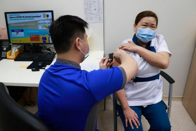 NCID senior staff nurse Sarah Lim, 46, receiving her vaccination in the Day Treatment Centre at NCID, on Dec 30, 2020. ST PHOTO: KEVIN LIM
