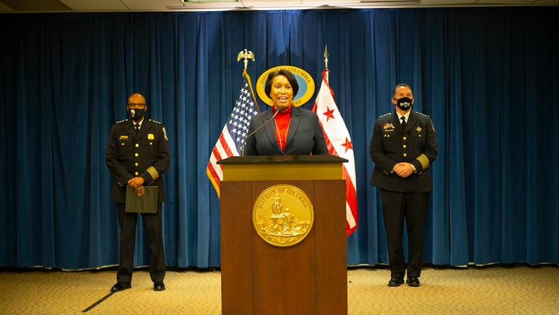 D.C. Mayor Muriel E. Bowser, center, with acting D.C. police Chief Robert Contee III behind and to her left on Dec. 22. MUST CREDIT: Photo by Robb Hill for The Washington Post.