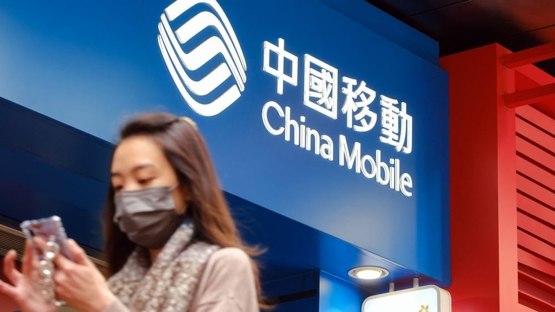 A pedestrian walks past a China Mobile store in Hong Kong on Jan. 4, 2021. MUST CREDIT: Bloomberg photo by Roy Liu.