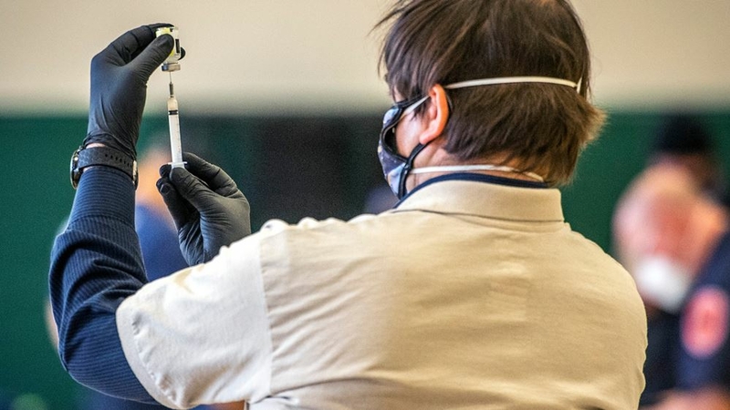 Hans Spigel inspects a dose of Moderna coronavirus vaccine in Silver Spring, Md., on Wednesday, Dec. 30. MUST CREDIT: Washington Post photo by Bill O'Leary