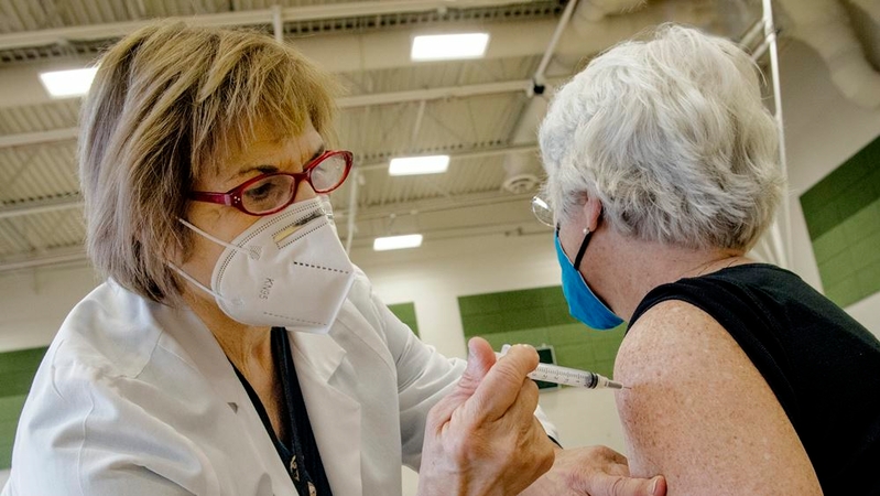 Registered Nurse Maryanne Morgan, left, gives a shot to Susan Dodge, a midwife, right, as Montgomery County administered 4,000 doses on Dec. 30. MUST CREDIT: Washington Post photo by Bill O'Leary.