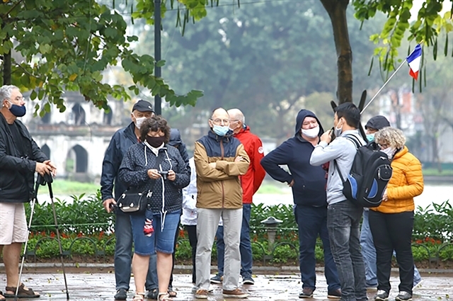 Tourists wear face masks in Hà Nội early last year. Tourism-related services like accommodation and transportation are still in a bleak situation due to cross-border travel restrictions. VNA/VNS Photo Minh Quyết