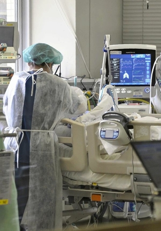 A nurse provides care to a patient infected with the novel coronavirus at a hospital in Fukuoka on Dec. 23, 2020. (The Yomiuri Shimbun)