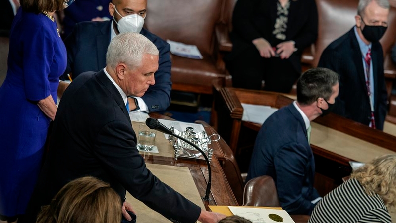 Vice President Mike Pence, presiding over Congress's affirmation of the election results on Jan. 6, passes a document to a staffer. MUST CREDIT: Washington Post photo by Bill O'Leary