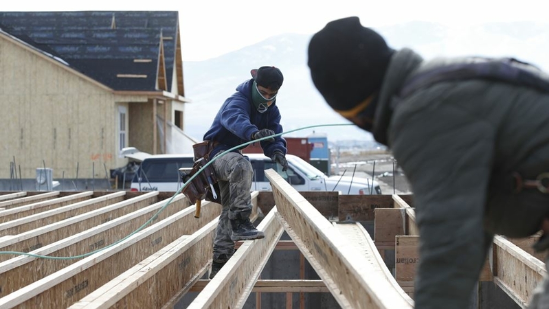 Contractors install floor beams on the foundation of a house under construction in Lehi, Utah, U.S., on Dec. 16, 2020. MUST CREDIT: Bloomberg photo by George Frey.