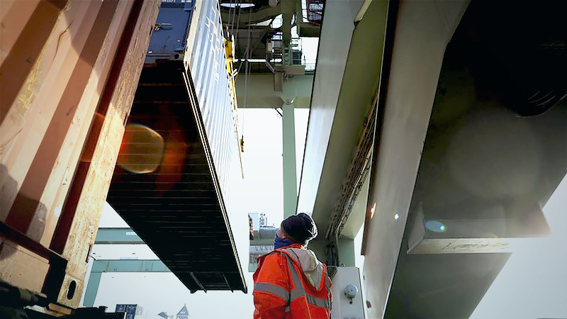 A dockworker monitors a shipping container being loaded onto a freight train at the railway terminal at Behala inland port in Berlin on Jan. 26, 2021. MUST CREDIT: Bloomberg