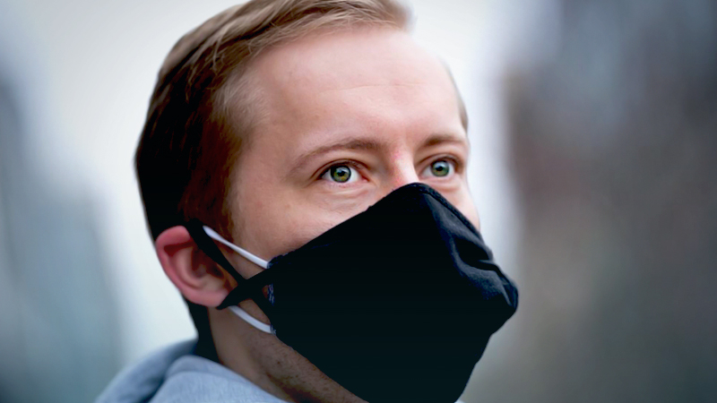 Danny Ryan, 27, is pictured wearing two masks on Wednesday near his home in Washington, D.C. Double masks are becoming a real possibility as a new virus variant makes its way from England, South Africa, and Brazil into the U.S. MUST CREDIT: Washington Post photo by Sarah L. Voisin.
