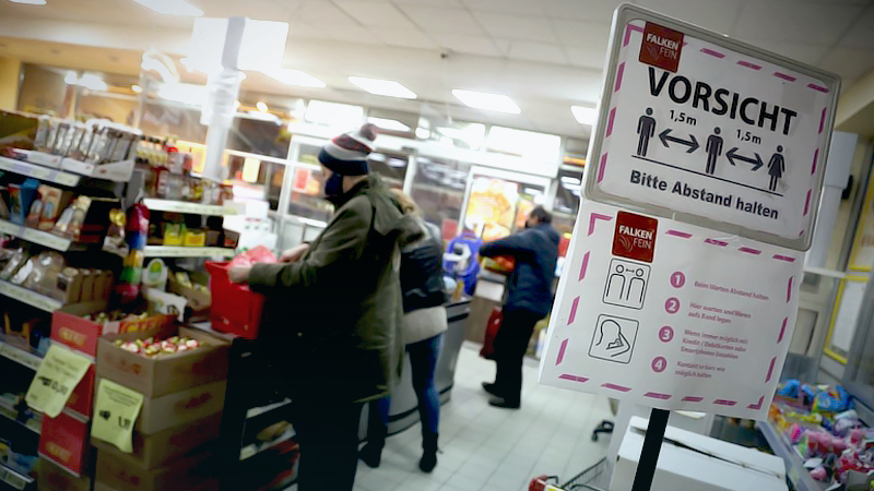 A social distancing sign stand near the checkout counters in a supermarket in Berlin on Jan. 19, 2021. MUST CREDIT: Bloomberg photo by Liesa Johannssen-Koppitz
