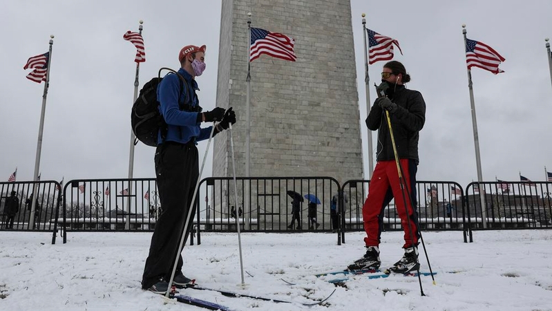 Travis Fondow, right, and a friend, prepare to ski near the Washington Monument in Washington on Sunday, Jan. 31, 2021. MUST CREDIT: Photo for The Washington Post by Oliver Contreras
