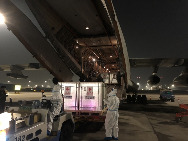 Workers in Beijing load COVID-19 vaccines onto an aircraft on Sunday before it departs for Pakistan. The vaccines, developed by China National Pharmaceutical Group, known as Sinopharm, arrived in Islamabad on Monday, making Pakistan the first country to receive COVID-19 vaccines donated by the Chinese government. [Photo/China Daily]
