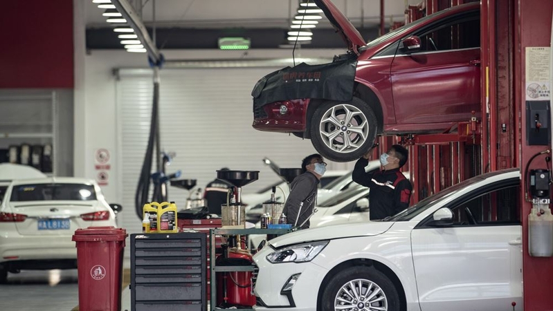 An employee inspects a vehicle at a Tuhu repair and service center in Shanghai on Feb. 3, 2021. MUST CREDIT: Bloomberg photo by Qilai Shen.