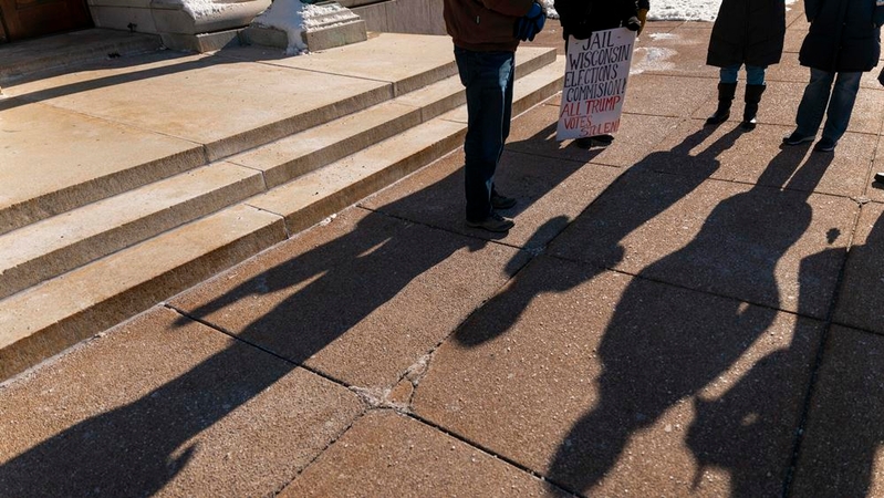 People pray outside the Wisconsin Capitol in Madison on Dec. 14, 2020, in a protest of the presidential election results. MUST CREDIT: Photo for The Washington Post by Darren Hauck