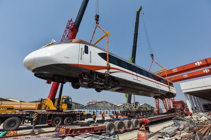 A subway train is hoisted onto a sidetrack in Guangzhou, Guangdong province, on Saturday. The train, the first to operate on the city's lines 18 and 22, will run at up to 160 kilometers per hour. The lines are expected to begin operating in June. [Photo/Xinhua]
