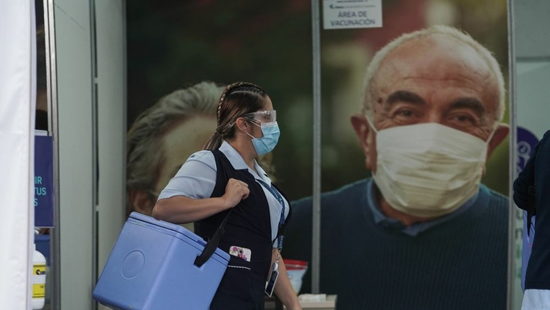 A health-care worker carries a container of Pfizer-BioNTech coronavirus vaccines in Bogota, Colombia, on Thursday, Feb. 18, 2021.