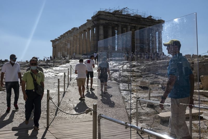 Visitors walk past protective plexiglass barriers towards the Parthenon at the archaeological site of the Acropolis in Athens, Greece, on July 22, 2020. MUST CREDIT: Bloomberg photo by Yorgos Karahalis.