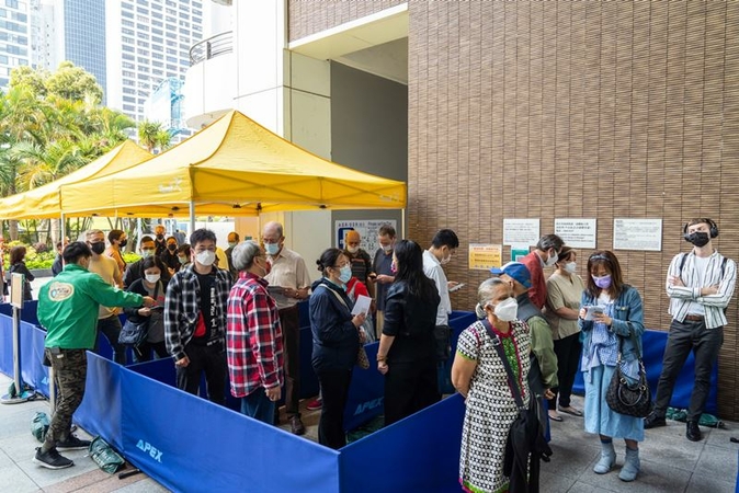 People stand in line outside a community vaccination center in Hong Kong on March 17, 2021. MUST CREDIT: Bloomberg photo by Chan Long Hei.
