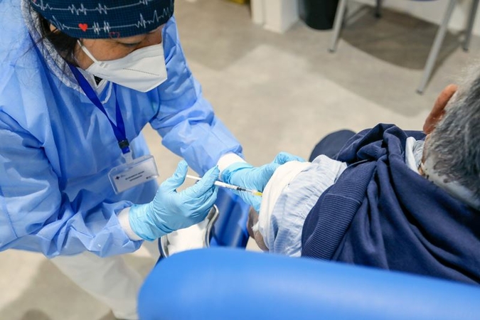 A health worker administers the Moderna Covid-19 vaccine to a visitor at a vaccination center in Rome on March 17, 2021. MUST CREDIT: Bloomberg photo by Alessia Pierdomenico.