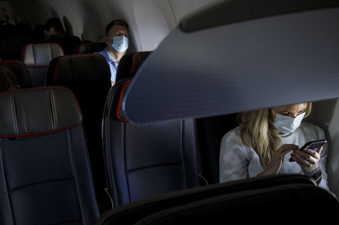 Passengers wear protective masks sit on a Boeing Co. 737-800 during an American Airlines Group Inc. flight departing from Los Angeles International Airport (LAX). Photographer: Patrick T. Fallon/Bloomberg