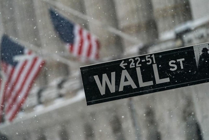 A Wall Street street sign outside the New York Stock Exchange as snow falls in New York on Feb. 1, 2021. MUST CREDIT: Bloomberg photo by Jeenah Moon.