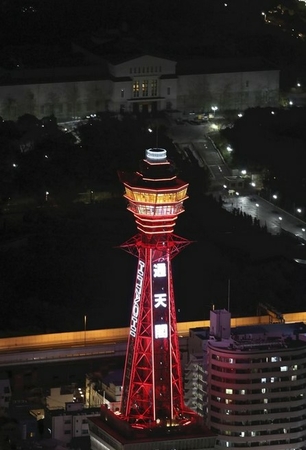 Tsutenkaku Tower is lit up in red in Osaka City on Wednesday after the Osaka prefectural government signaled a “red light,” the emergency level under its own coronavirus warning system. (The Yomiuri Shimbun)