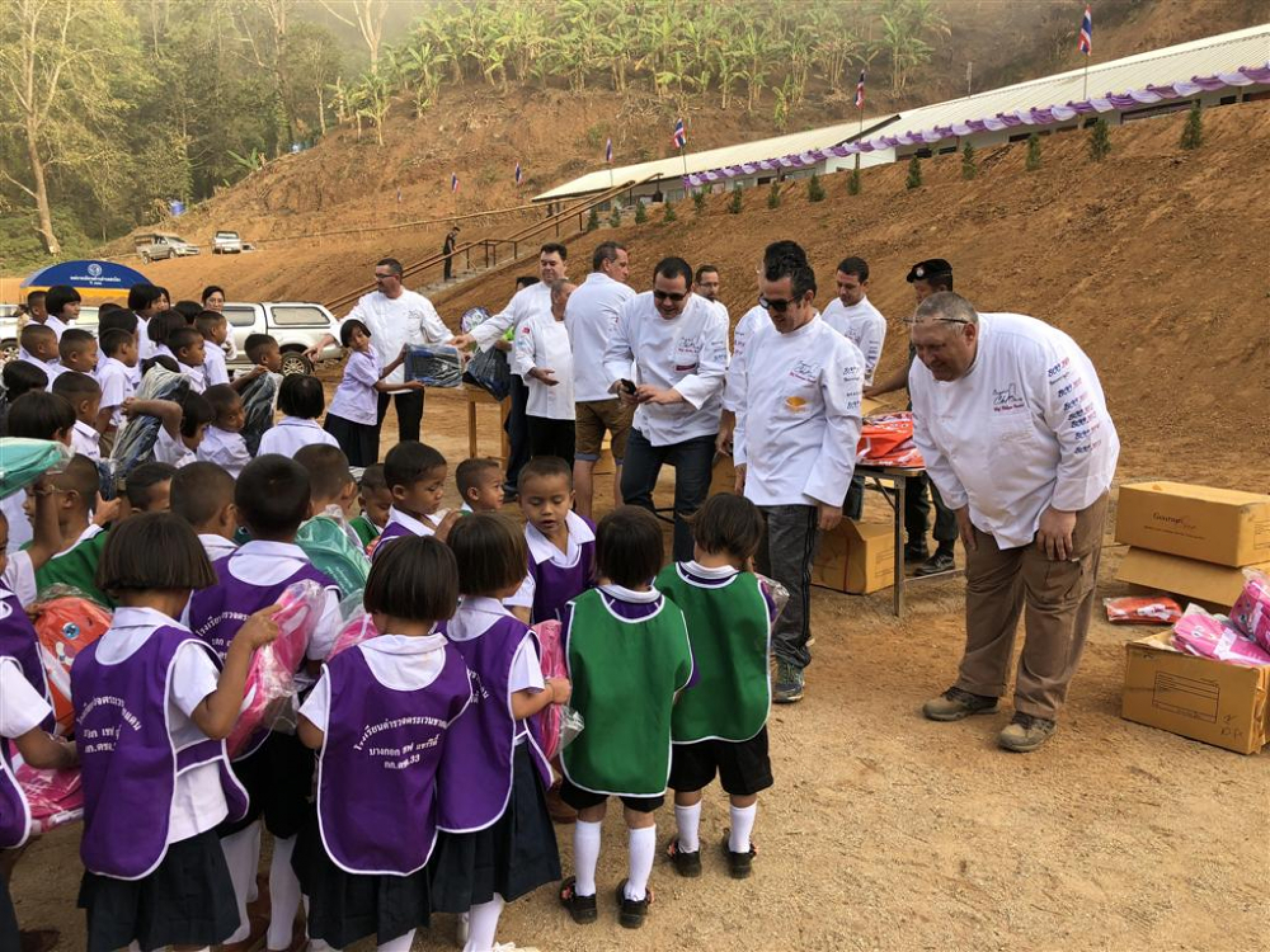 The chefs took delight in presenting gifts to the children.