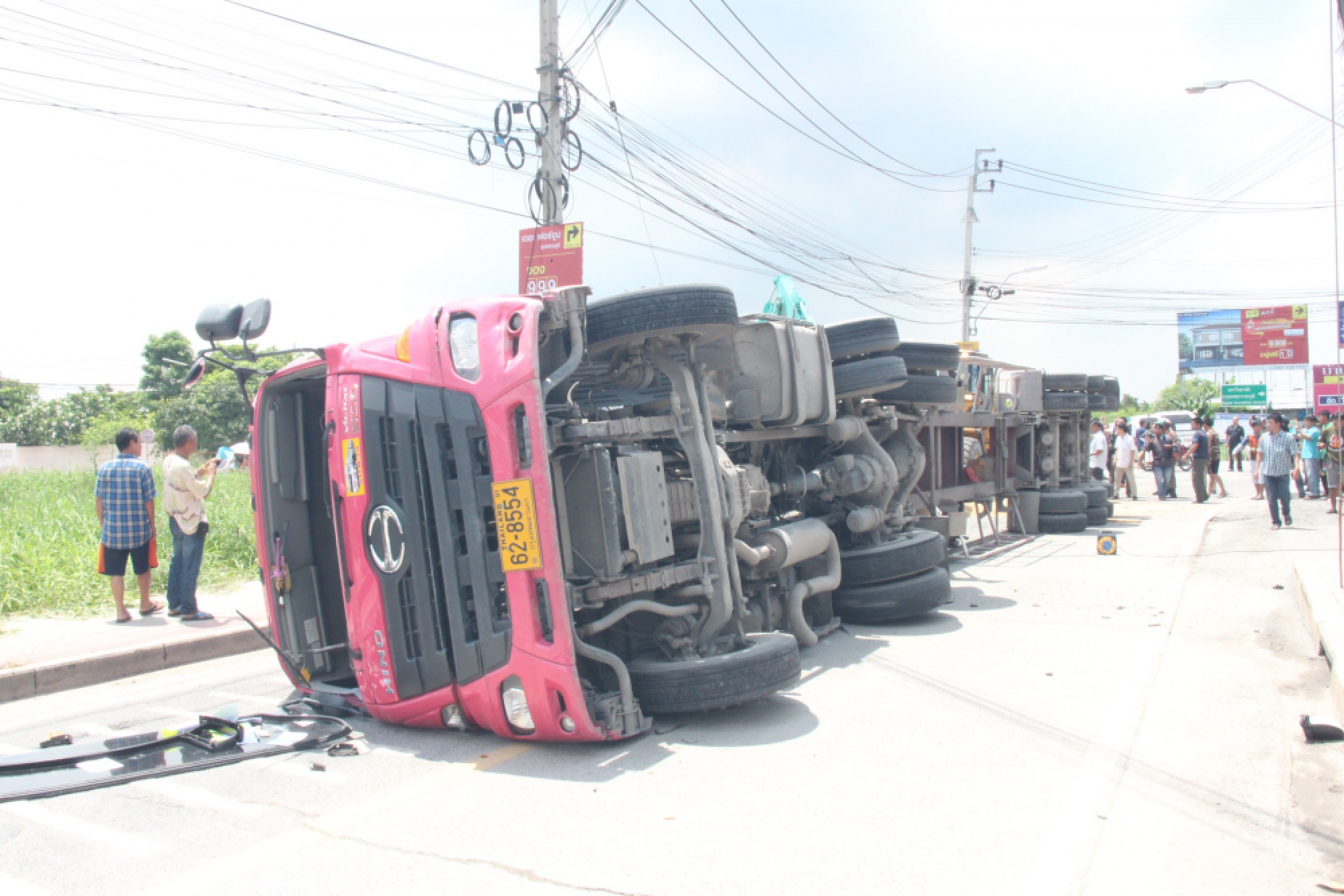 Driver cut free after truck carrying soybeans tips over on to his car