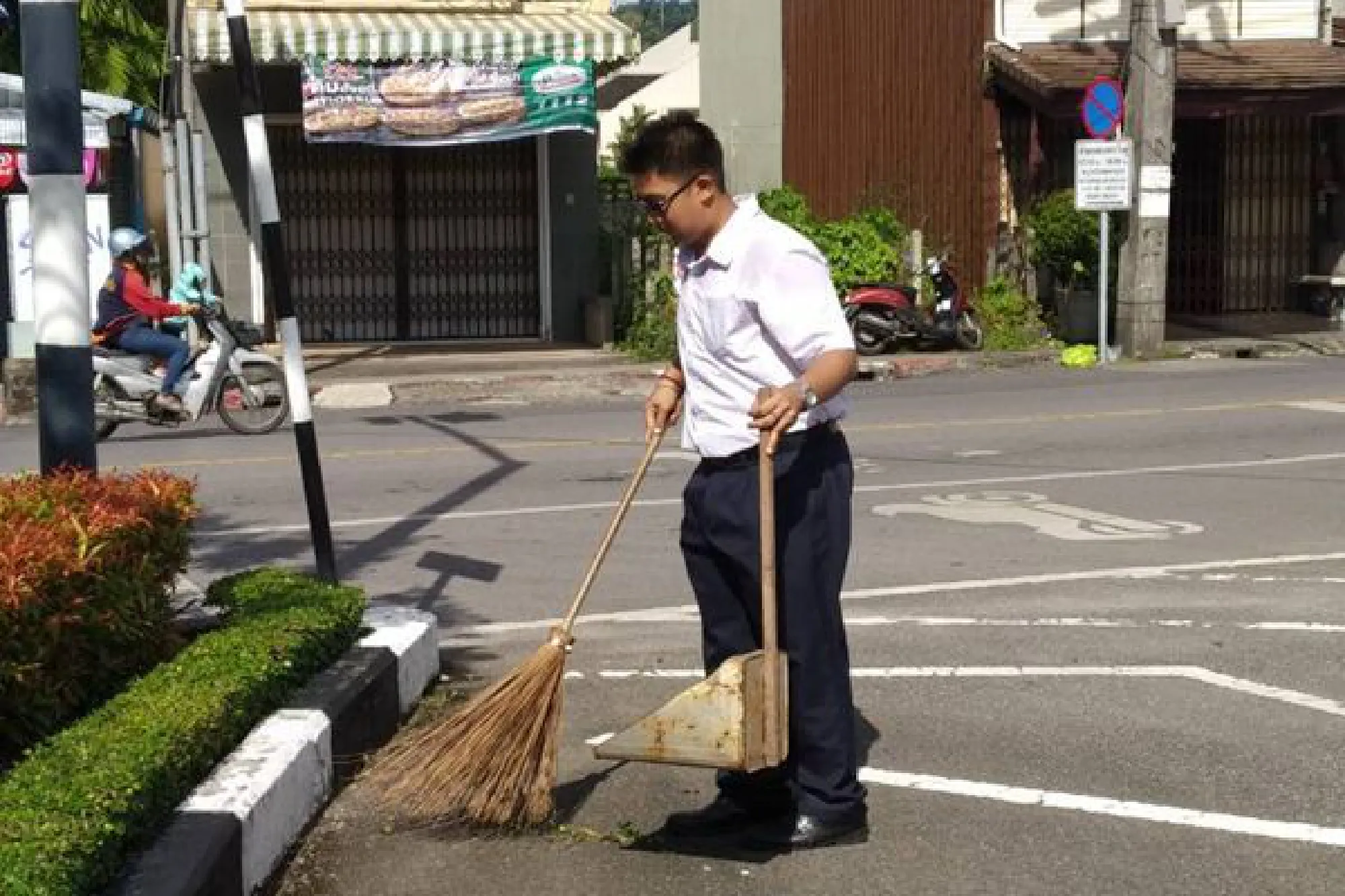 Phuket teen cleans roads before school