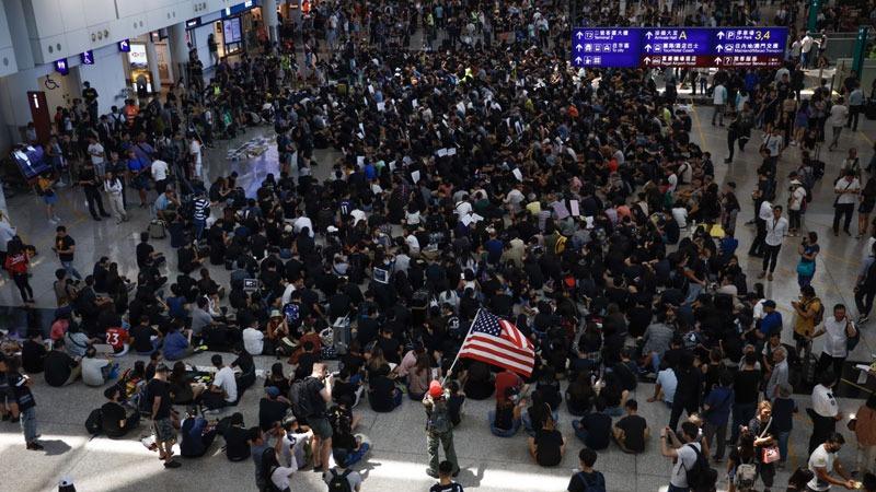 Black-clad protesters take part in a sit-in at the arrivals hall of the Hong Kong International Airport on Aug 9, 2019. (PHOTO / CHINA DAILY)