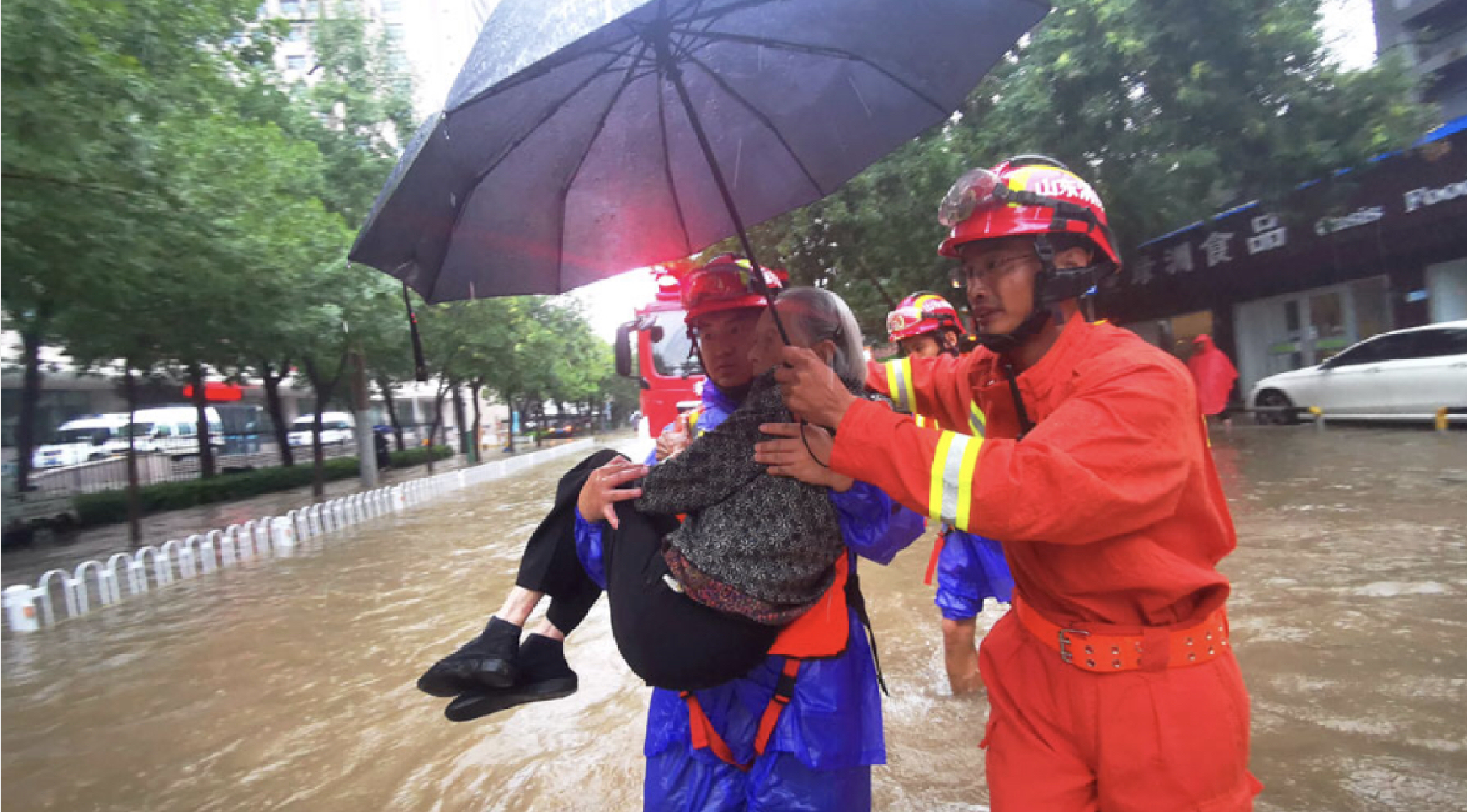 Rescuers carry an elderly woman to safety after she was stranded in a vehicle in a flooded street in Binzhou, Shandong province, on Sunday. [Photo/Xinhua]