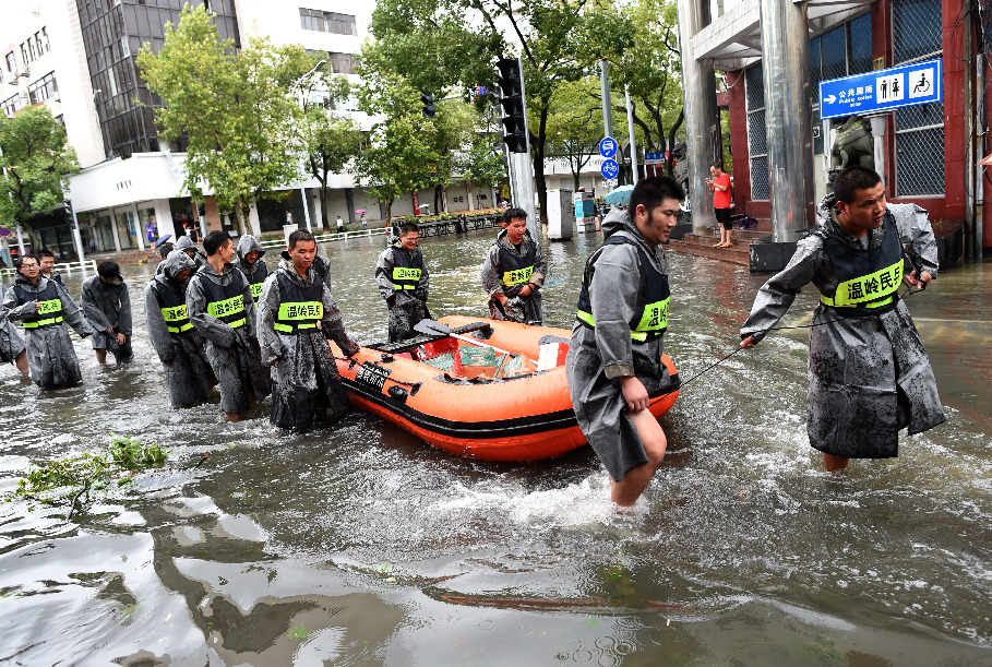 Staff members transport relief supplies via a rubber dinghy in Wenling, East China's Zhejiang province, Aug 10, 2019. [Photo/Xinhua]