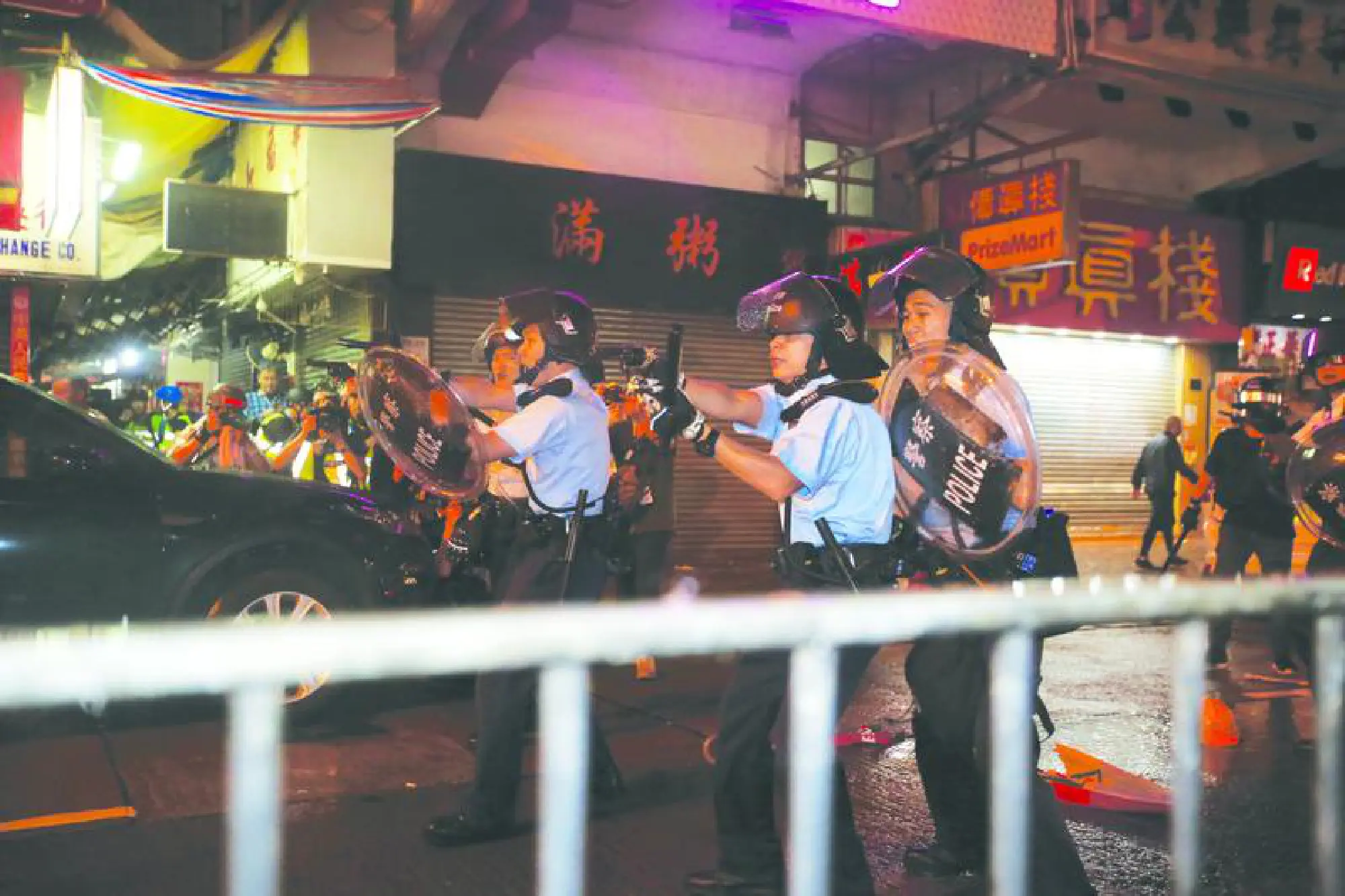 Police officers under assault have their guns drawn in Sunday's dispersal operations.