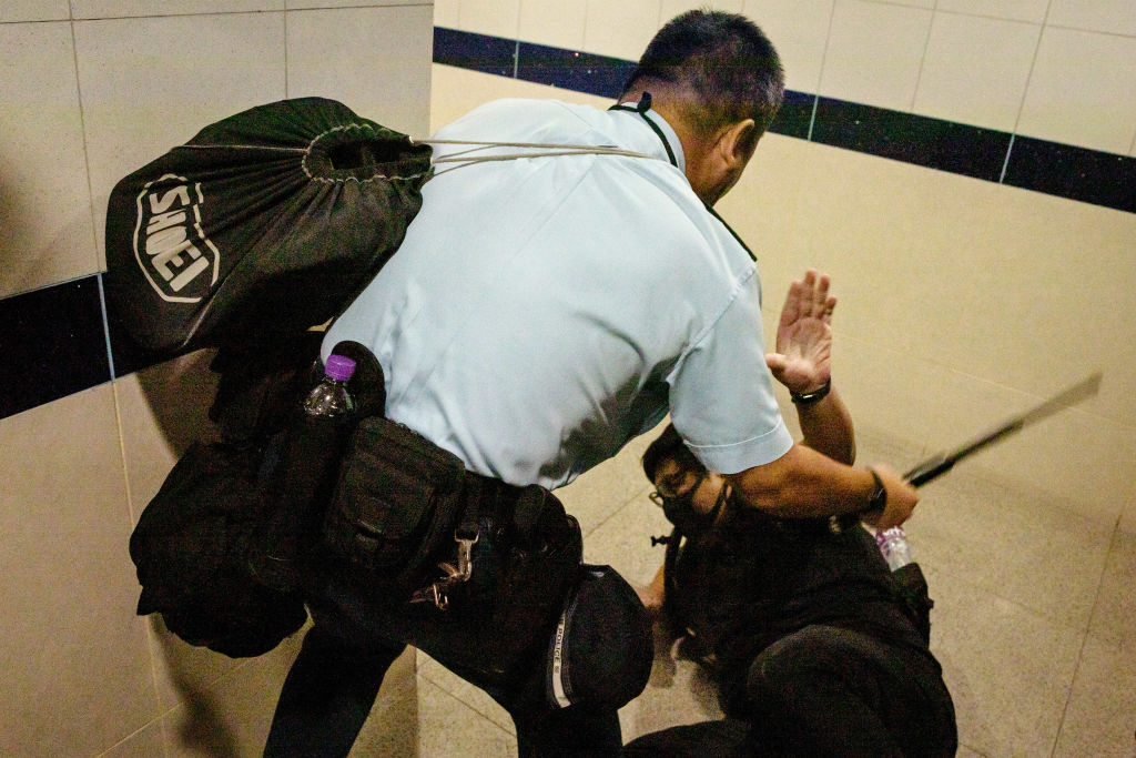 HONG KONG, CHINA - SEPTEMBER 01: A police man beats a protester in the men toilet inside Hong Kong International Airport on September 1, 2019 in Hong Kong, China. (Photo by Chris McGrath/Getty Images)