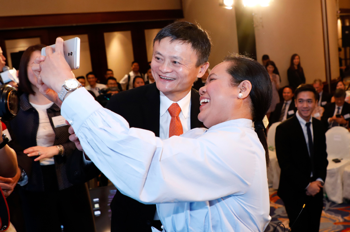 Jack Ma poses for a photo with the first user of blockchain-enabled AlipayHK in Hong Kong on June 25, 2018, after she sent money through AlipayHK to Gcash, a Philippine e-payment application, at the launch event of the cross-border e-payment service. [Photo/for China Daily]