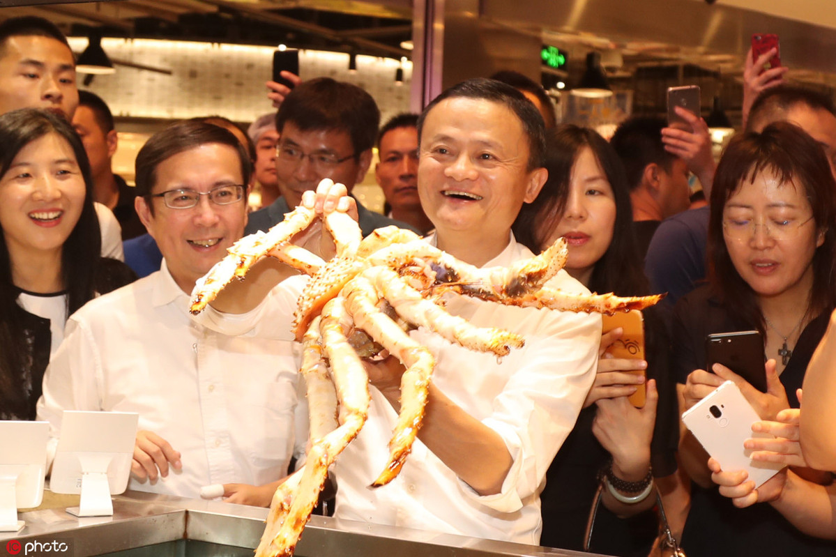 Jack Ma grabs a king crab at Hema Xiansheng of Hema Fresh, a newly emerged retail chain focusing on fresh food, in Shanghai, July 14, 2017. [Photo/IC]