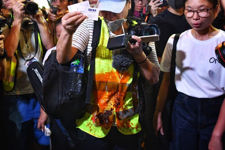 A woman accused of a being a fake reporter has red liquid thrown at her by protesters in Mong Kong, Hong Kong, on Oct 13, 2019.ST PHOTO: CHONG JUN LIANG