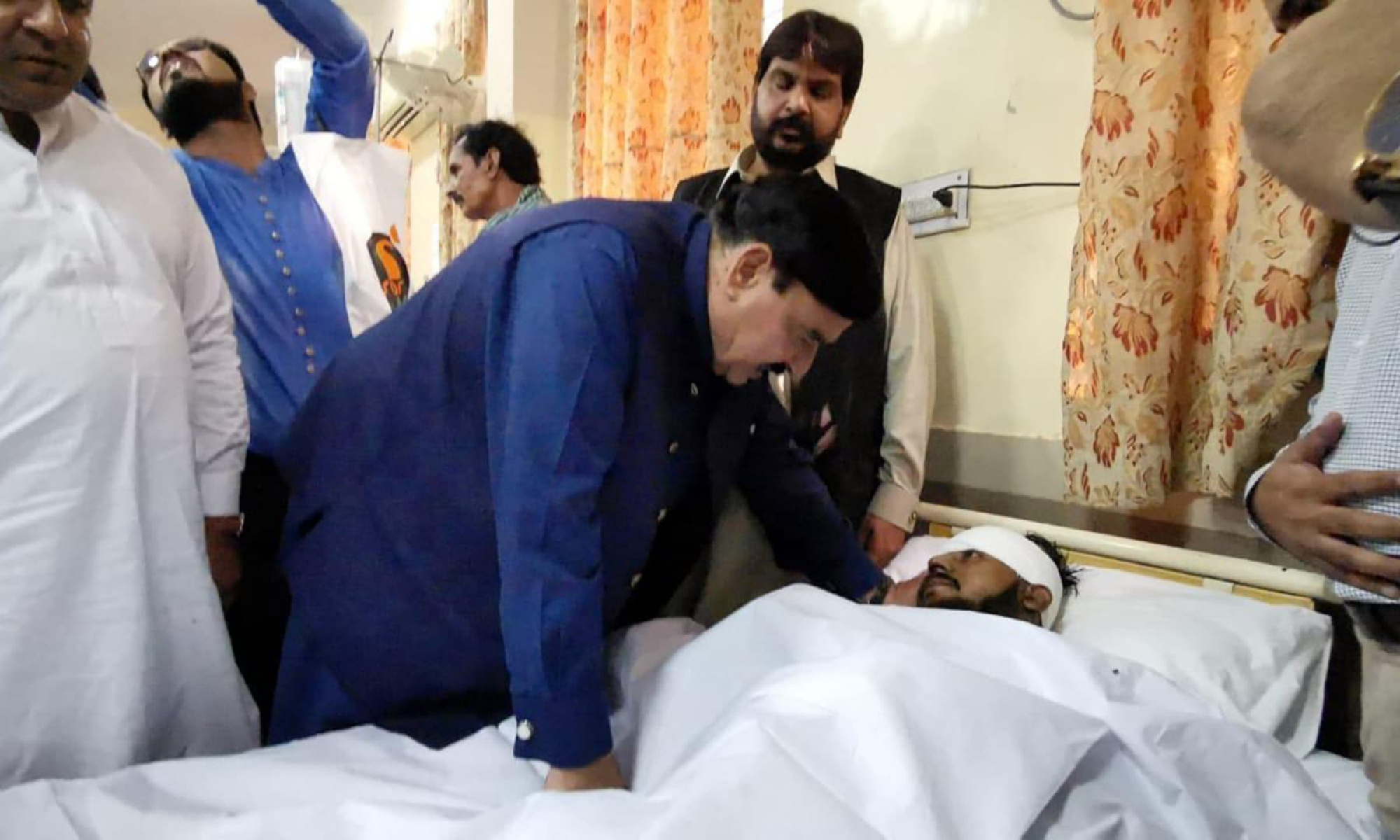 Railways Minister Sheikh Rashid Ahmed asking after a patient at the Sheikh Zayed Hospital in Rahim Yar Khan on Thursday. — Photo provided by Adnan Sheikh