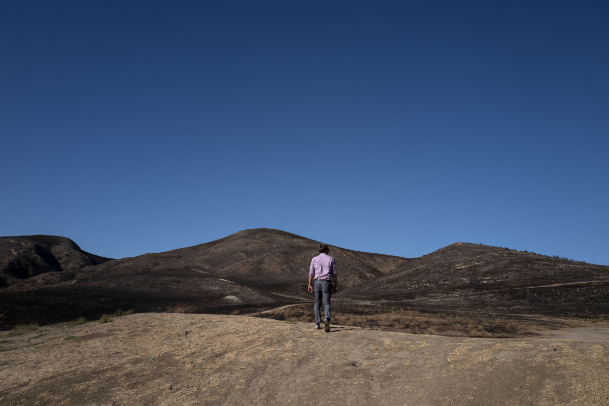 A man walks across a dried and burned out landscape, a result of the Real Fire, in Goleta, Calif. The Real Fire scorched more than 400 acres in mid-October but was quickly contained due to heightened awareness and readiness by local fire departments. MUST CREDIT: Washington Post photo by Michael Robinson Chavez