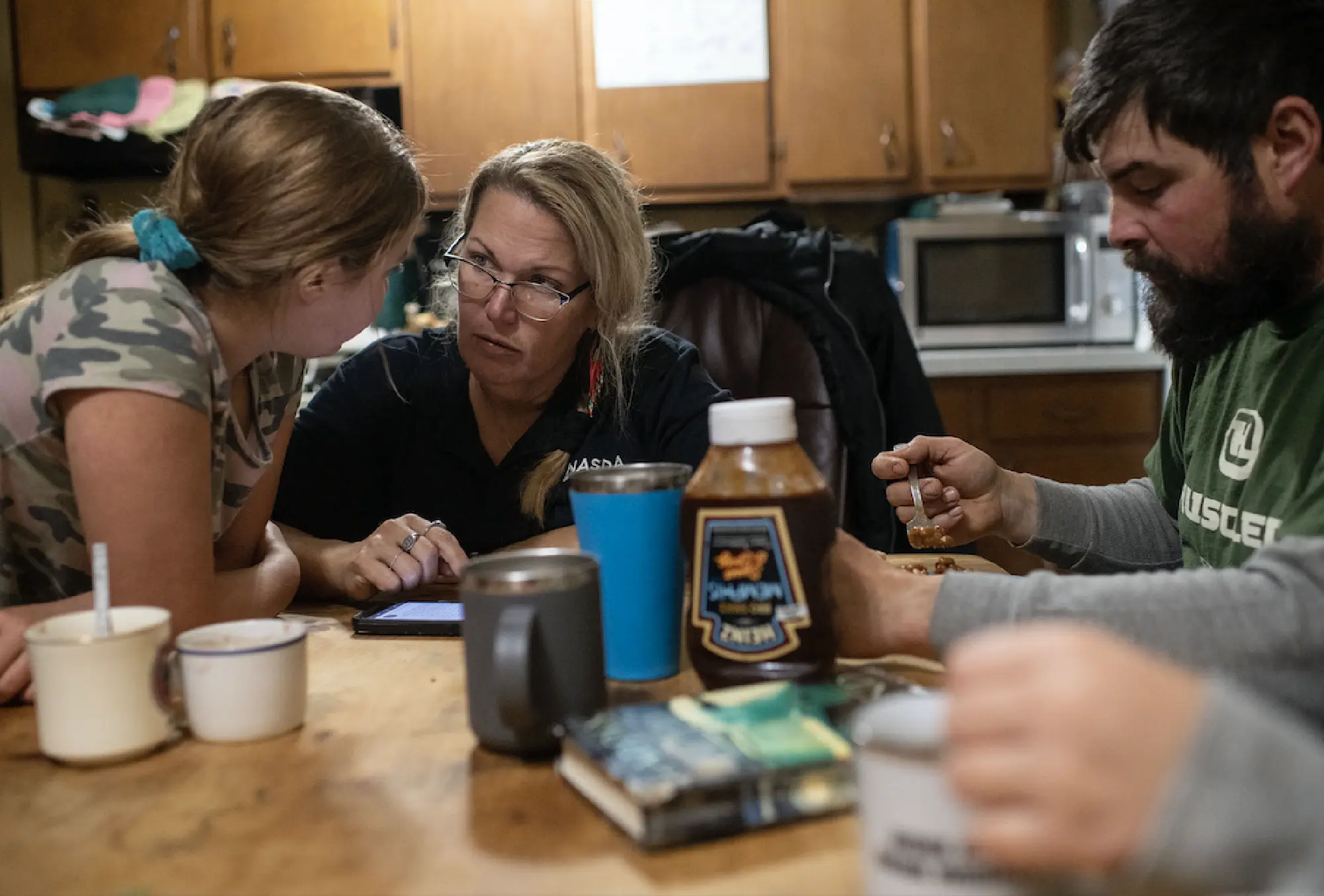 Brooke Lee, 9, and her mother, Anne Lee, read an article out loud about projected milk prices for 2020 during dinner Dec. 4 at the Lee family's dairy farm in Berkshire, N.Y. MUST CREDIT: Washington Post photo by Carolyn Van Houten