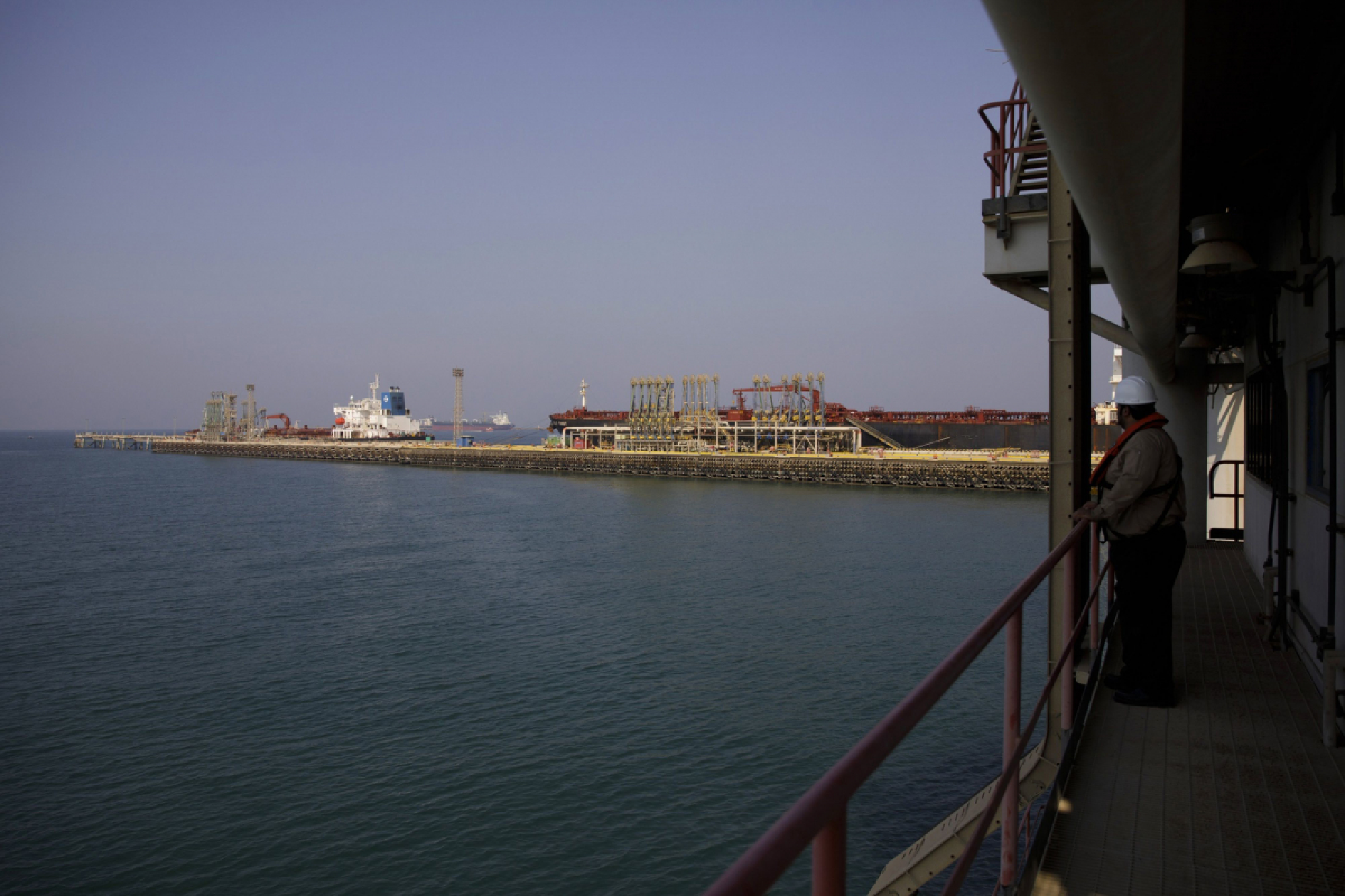 An employee watches oil tankers being loaded with oil for shipping at the North Pier Terminal, operated by Saudi Aramco, in Ras Tanura, Saudi Arabia, on Oct. 1, 2018. MUST CREDIT: Bloomberg photo by Simon Dawson.
