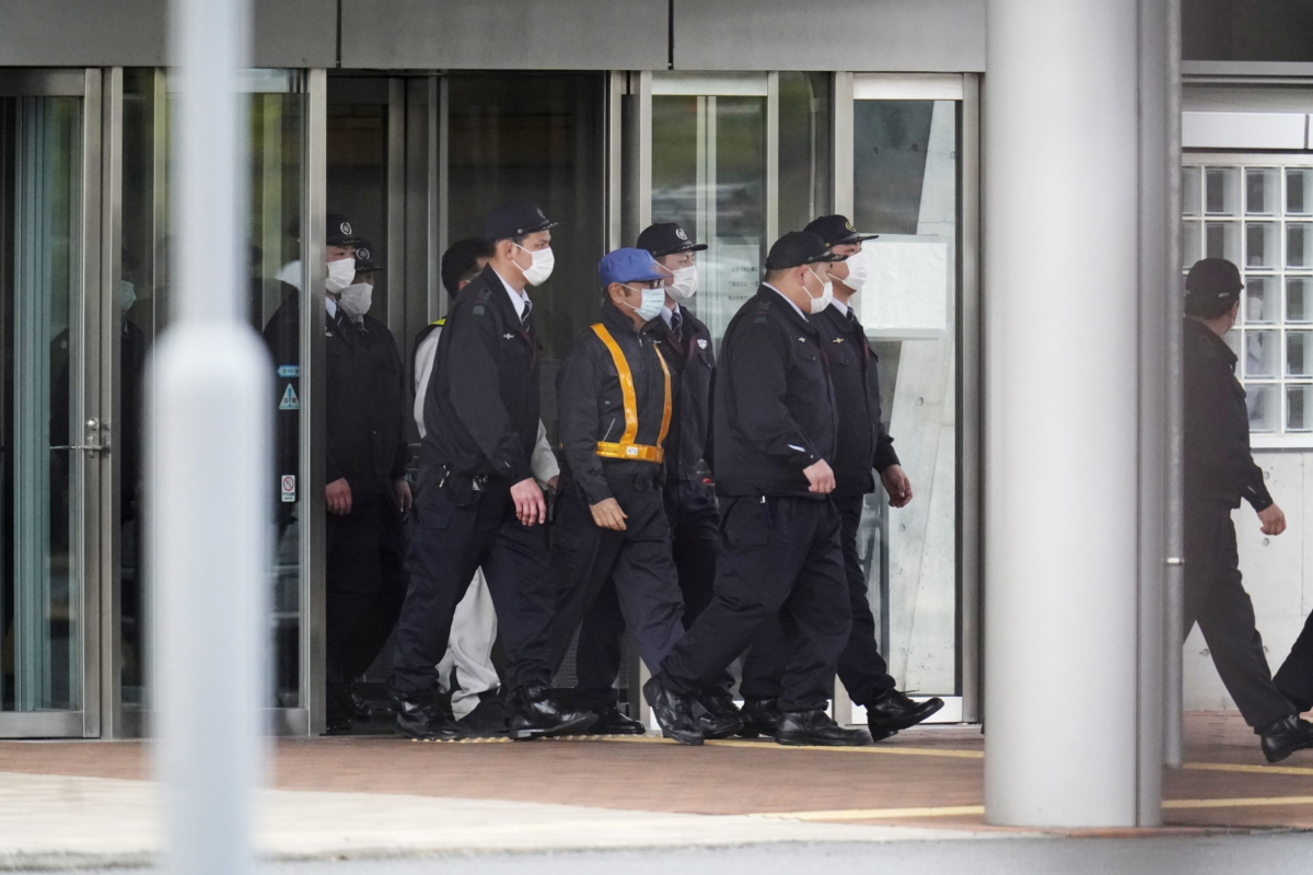 Carlos Ghosn, former chairman of Nissan (center in blue hat) walks out of the Tokyo Detention House in Tokyo, on March 6, 2019. MUST CREDIT:Bloomberg photo by Toru Hanai.