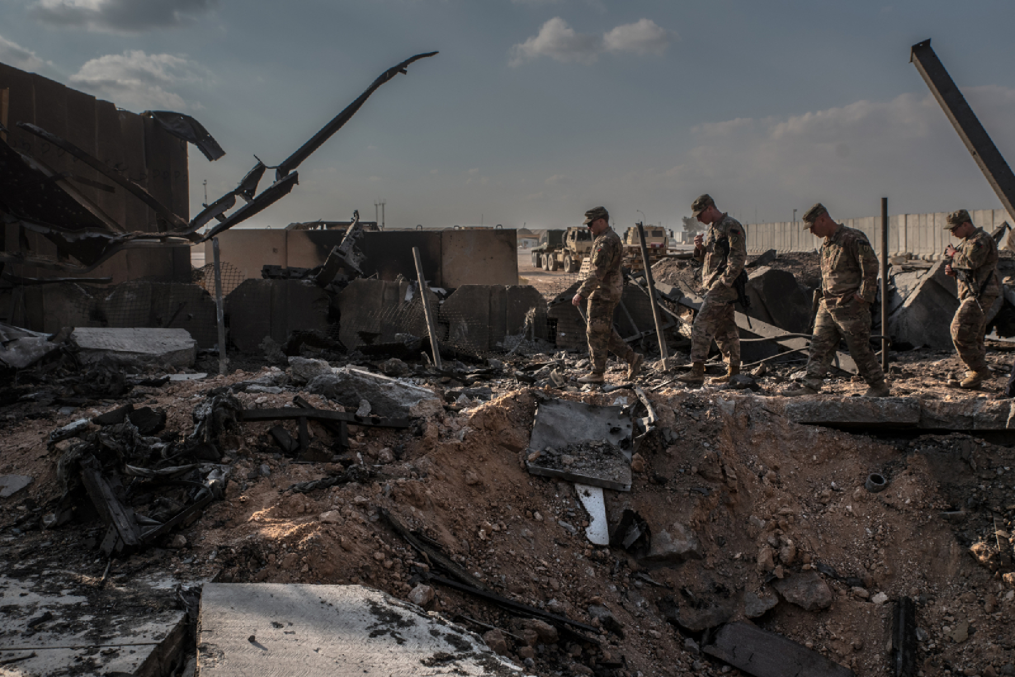U.S. officials stand near a crater caused by Iranian airstrikes inside the Ain al-Asad base near Anbar, Iraq, on Jan. 13, 2019. MUST CREDIT: Photo for The Washington Post by Emilienne Malfatto