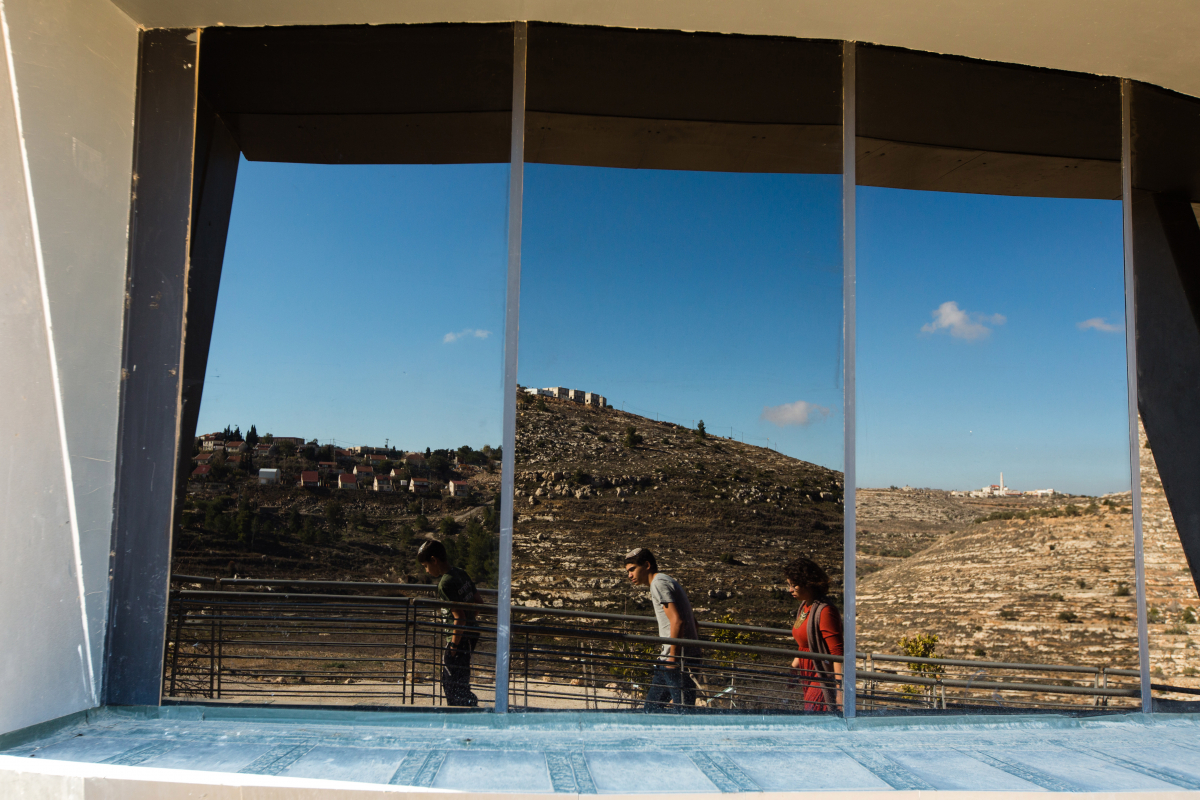 The West Bank Jewish settlement of Shiloh, left, is reflected in windows of the lookout tower at the archaeological park of Ancient Shiloh. The right window reflects a nearby Palestinian village. MUST CREDIT: Photo for The Washington Post by David Vaaknin