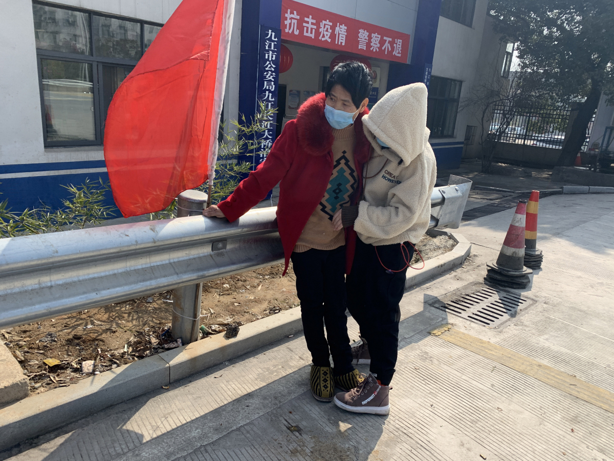 Shi Zhiyu, 15, helps her grandmother Ying Quanlong, 55, cross a bridge back home. They have been separated from their family for nearly two weeks after the closure of the bridge. MUST CREDIT: Washington Post photo by Gerry Shih