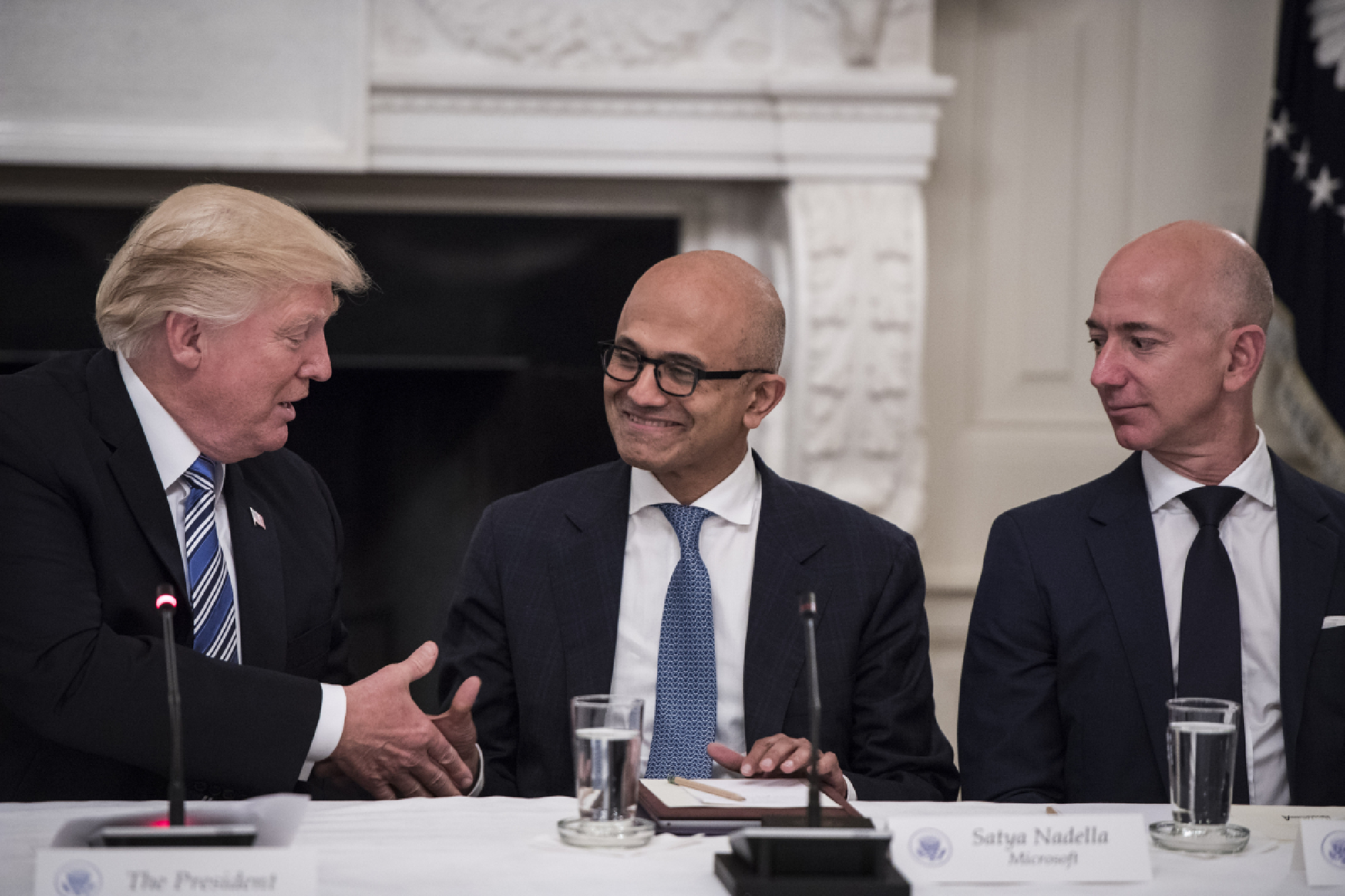 President Trump greets Satya Nadella (center), Microsoft CEO, and Jeff Bezos, Amazon CEO, during an American Technology Council roundtable at the White House in 2017. MUST CREDIT: Washington Post photo by Jabin Botsford.