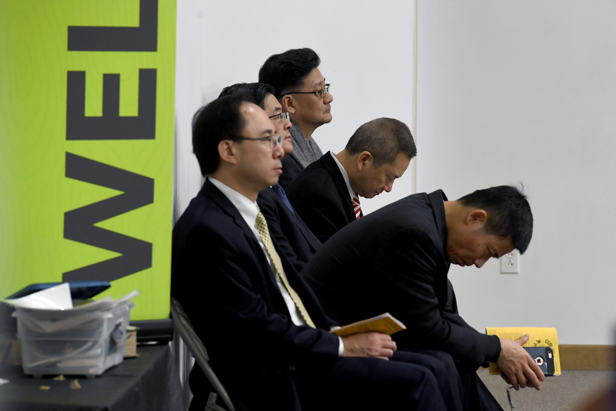 Luke Gao, right, bows his head during the Mandarin service at the Chinese Bible Church of Maryland in Rockville, Maryland, on Sunday, Feb. 16, 2020. It was his first Sunday back at church after self-quarantining for two weeks after returning from China. MUST CREDIT: Washington Post photo by Katherine Frey