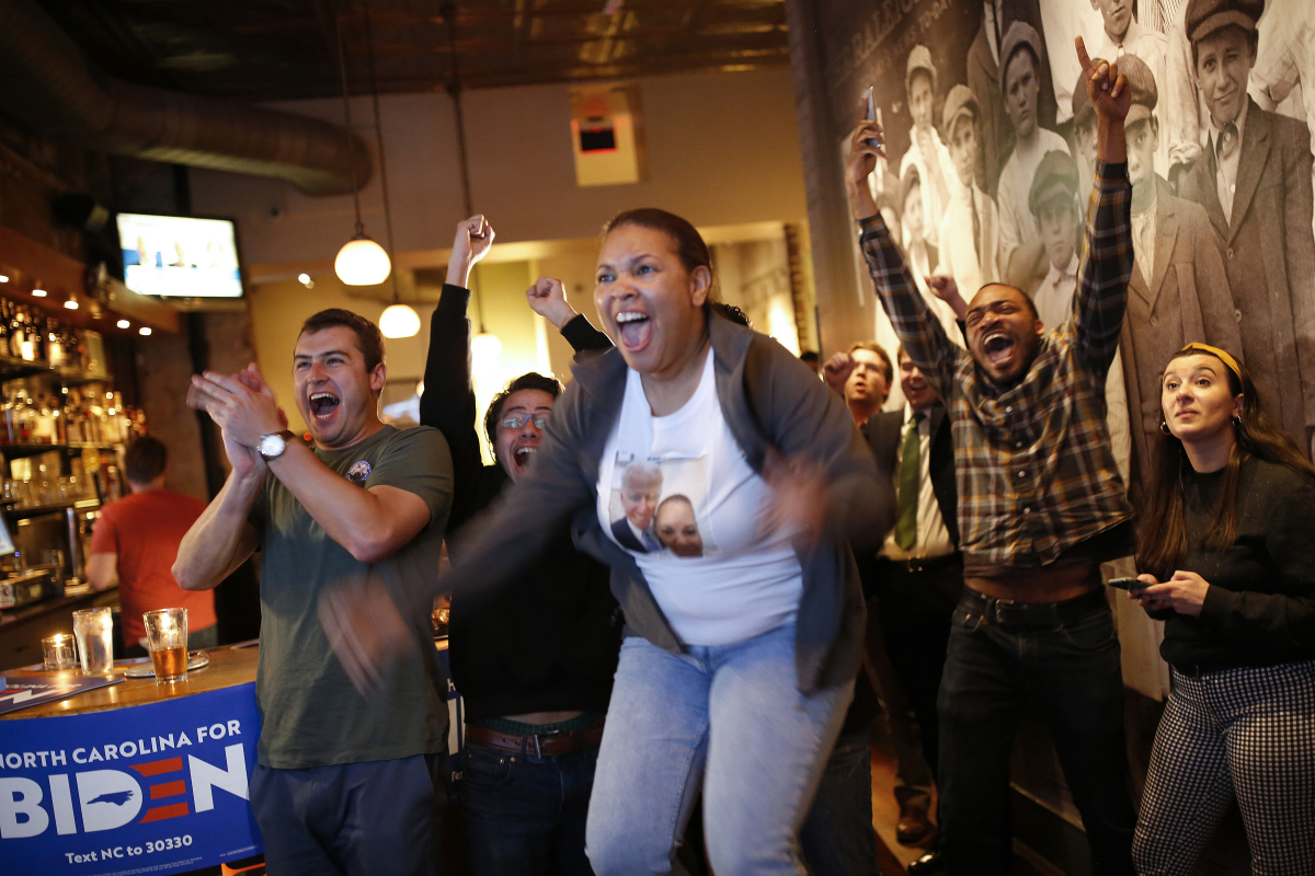 Nervahna Crew, center, leaps into the air as she celebrates with other Joe Biden supporters as CNN calls North Carolina for the former vice president in the Democratic primary Tuesday night. MUST CREDIT: Photo by Eamon Queeney for The Washington Post