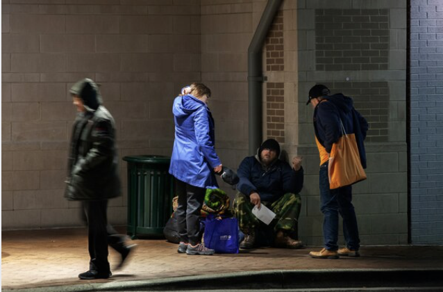 Gabriel Santos and Deborah Taylor, of the outreach organization Bethesda Cares, talk with a homeless person about the coronavirus on March 17, 2020, in Silver Spring, Md. MUST CREDIT: Photo for The Washington Post by by Robb Hill